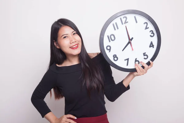 年轻的亚裔女子 和一个白色背景上的时钟 — 图库照片