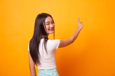 Asyalı kadın belgili tanımlık perde ile parlak sarı arka plana parmağına dokunmak