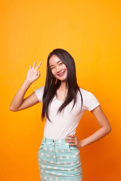 明るい黄色の背景に署名若いアジア女性ショー — ストック写真