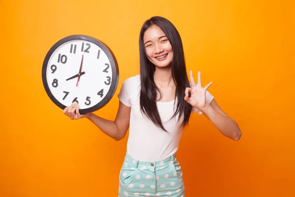 Joven Mujer Asiática Muestran Con Reloj Sobre Fondo Amarillo Brillante — Foto de Stock