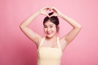 Pembe arka planda el işareti yapan genç Asyalı kadın.