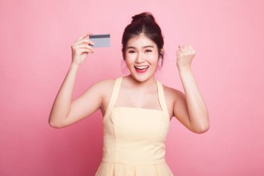 Pembe arka planda boş kartı olan genç Asyalı kadın yumruk pompası.