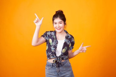 Genç Asyalı kadın nokta ile sarı arka plan tropikal forması elinde iki