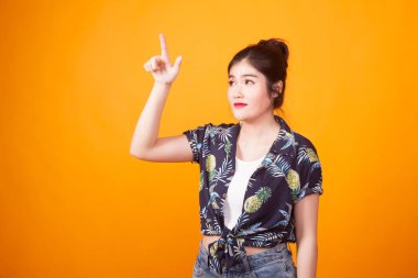 Asyalı kadın parmağını sarı zemin üzerine tropikal gömlekli ile ekranın dokunmadan