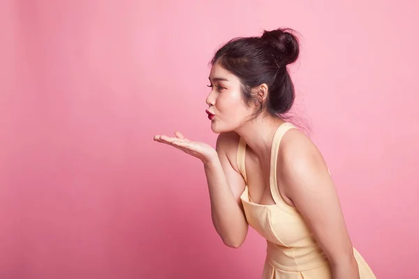 ピンクの背景に美しい若いアジア女性にキスを吹く — ストック写真