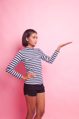 Pembe arka planda eli olan genç bir Asyalı kadın var.