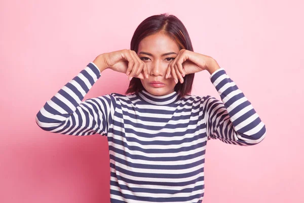 Young Asian woman sad and cry on pink background