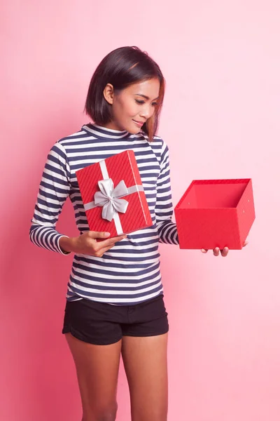 年轻的亚洲女人打开一个粉色背景的礼品盒 — 图库照片