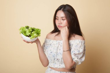 Asyalı kadın bej arka planda salatadan nefret eder