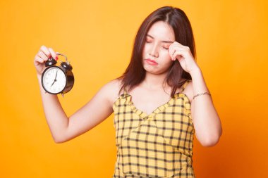 Uykulu genç Asyalı kadın ile sarı zemin üzerine sabah bir saat