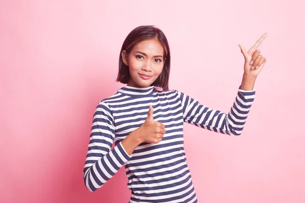 若いですアジアの女性ポイントと親指アップピンクの背景 — ストック写真