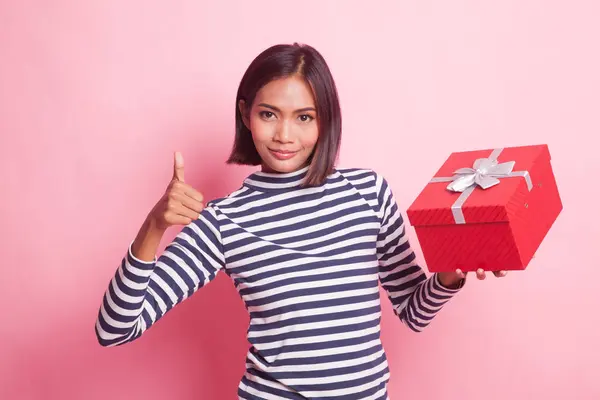 アジアの女性親指アップとともにギフトボックス上のピンクの背景 — ストック写真