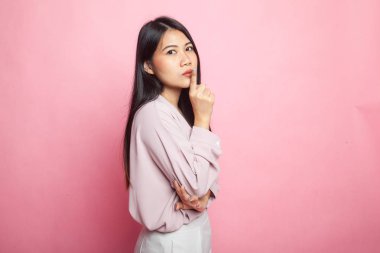 Asyalı kız pembe arka planda el işareti gösteriyor.
