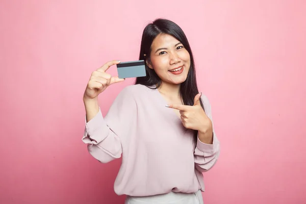 아시아의한 여자는 분홍색 배경에 카드를 가리킵니다 — 스톡 사진