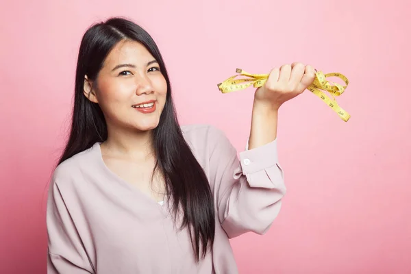 ピンクの背景に巻尺を持つ若いアジア女性 — ストック写真