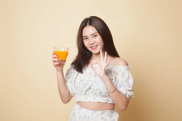 아시아 베이지 배경으로 오렌지 주스를 한잔씩 마시는 — 스톡 사진