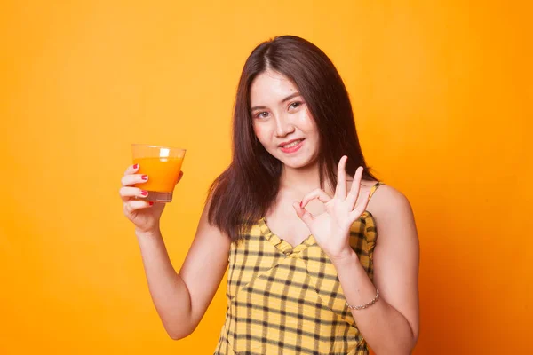 Jovem Mulher Asiática Mostrar Beber Suco Laranja Fundo Amarelo — Fotografia de Stock