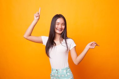 Genç Asyalı kadın noktası parlak sarı zemin üzerine iki elle