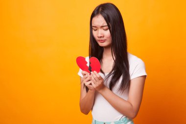 Güzel genç Asyalı kadın ile parlak sarı zemin üzerine kırık kalp