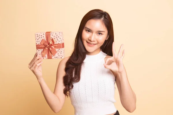 Молодая Азиатка Показывает Подарочной Коробкой Бежевом Фоне — стоковое фото