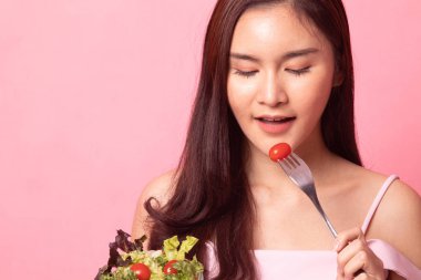 Güzel genç Asyalı kadın aşk diyet salata pembe bir arka plan üzerinde portresi