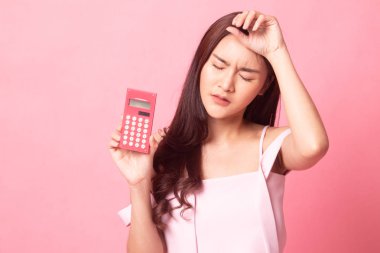 Pembe bir arka plan üzerinde hesap makinesiyle güzel genç Asyalı kadın portresi