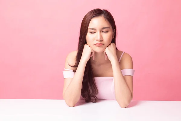 Asian girl with sad emotion on pink background
