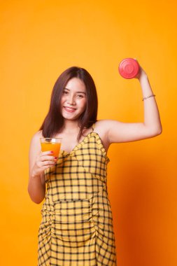 Genç Asyalı kadın dumbbell içki portakal suyu Sarı zemin üzerine