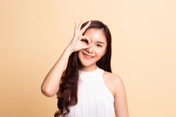 Hermosa Joven Asiática Mostrar Signo Sobre Ojo Sobre Fondo Beige — Foto de Stock