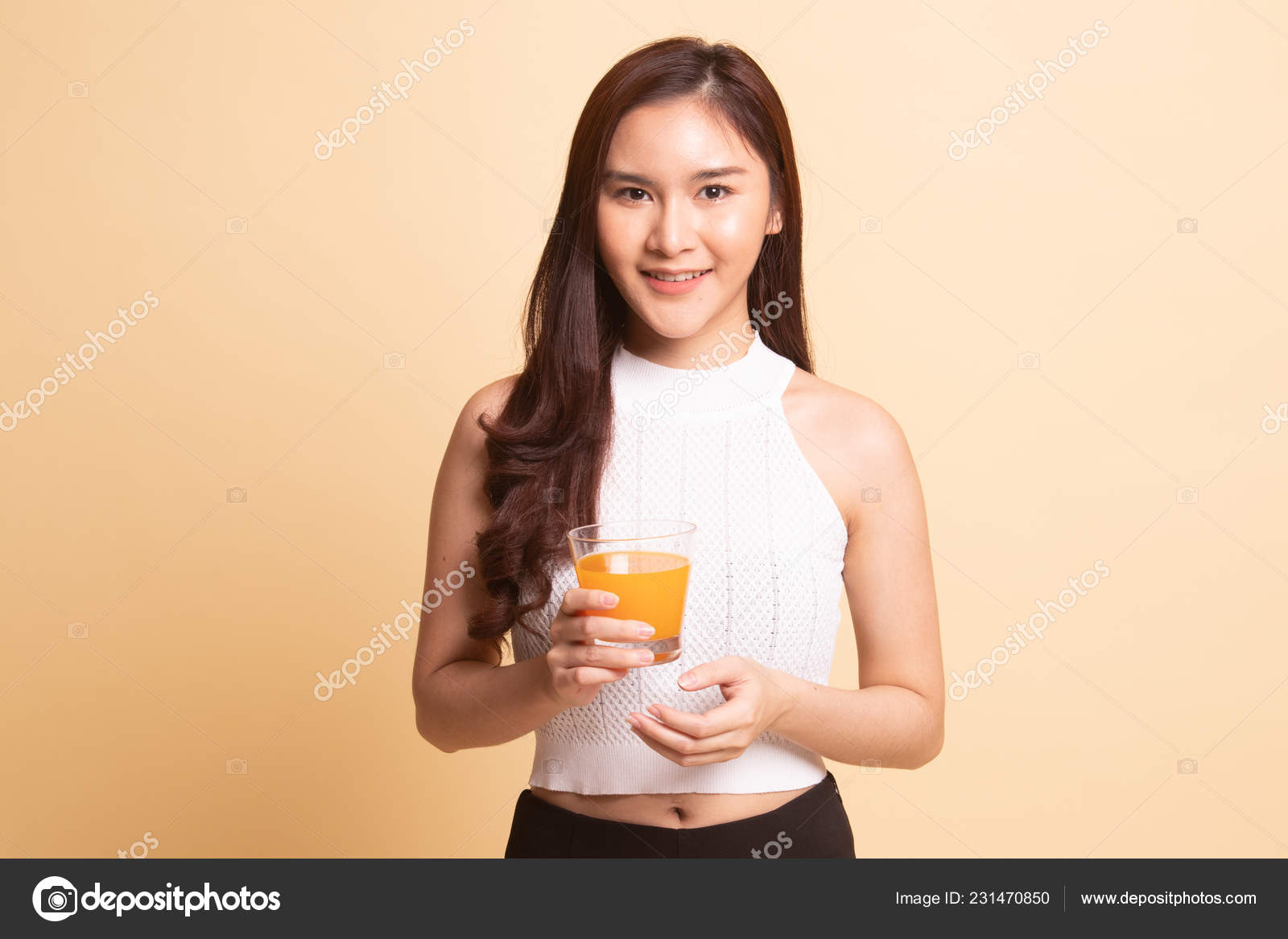 若いアジア人女性飲むオレンジジュースオンベージュ背景 ストック写真 C Halfbottle