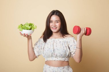 Kol halkaları ve bej arka planda salatası olan sağlıklı Asyalı kadın.