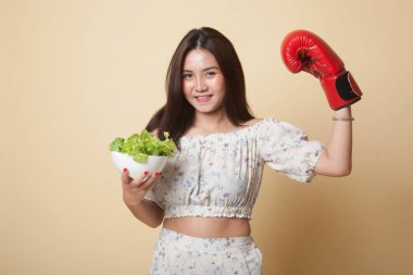 Genç Asyalı kadın ile boks eldiven ve salata bej renkli arka plan üzerinde