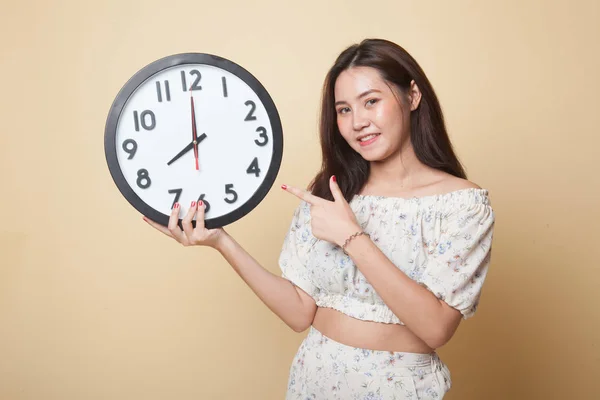 Young Asian Woman Point Clock Beige Background — Stock Photo, Image