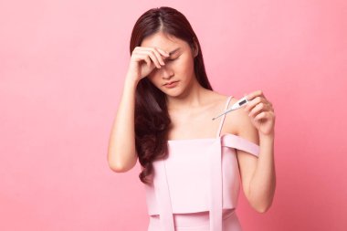 Genç Asyalı kadın hastalandı ve pembe arka planda grip.