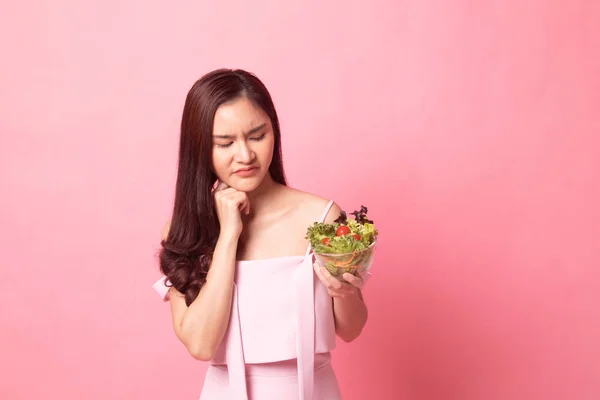 若いアジア女性の幸せではないピンクの背景にサラダが嫌い — ストック写真