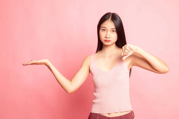 Ung Asiatisk Kvinna Visa Handflatan Och Tummen Ner Rosa Bakgrund — Stockfoto