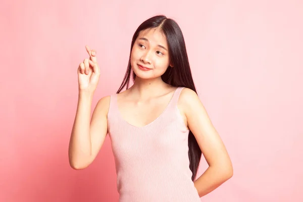 美丽的年轻亚洲女人在粉红的背景上交叉手指 — 图库照片