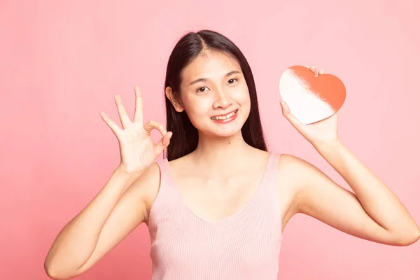 亚洲女人显示红色的心在粉红色的背景确定 — 图库照片