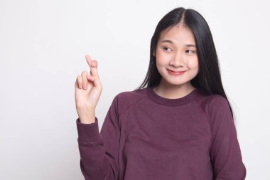 Güzel genç Asyalı kadın çapraz parmak beyaz arka plan üzerinde