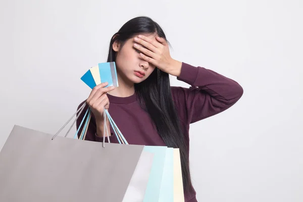 買い物袋と白い背景の上クレジット カード不幸な若いアジア女性 — ストック写真