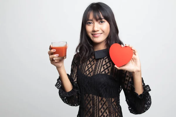 Молодая азиатка с томатным соком и красным сердцем . — стоковое фото