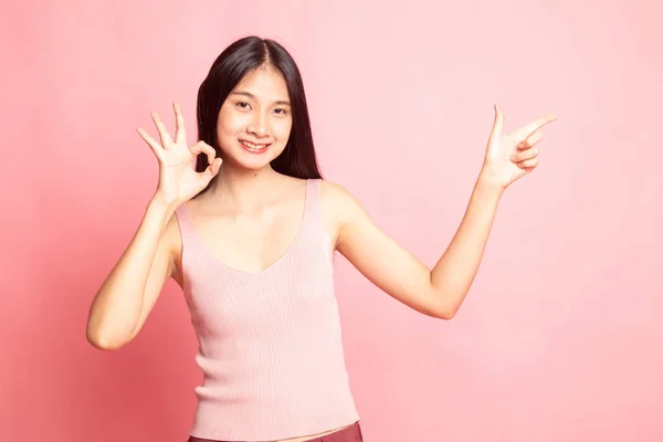 Ung asiatisk kvinna peka och Visa Ok. — Stockfoto