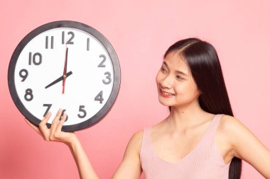 Saati olan genç Asyalı kadın..