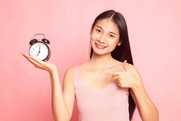 Joven asiática mujer punto a un reloj . —  Fotos de Stock