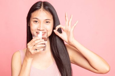 Genç Asyalı kadın göster Ok ile içme suyu bir bardak.