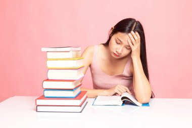 Yorgun genç Asyalı kadın kitapları tablo ile bir kitap okumak.