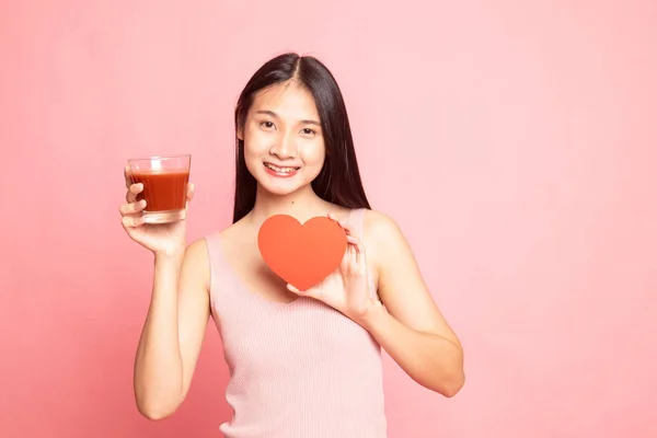 Ung asiatisk kvinna med tomat juice och rött hjärta. — Stockfoto