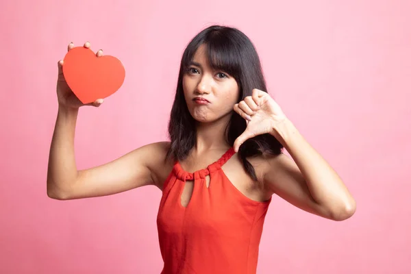 Asiatisk kvinna tummen ner med rött hjärta. — Stockfoto