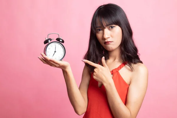 Arg ung asiatisk kvinna punkt till en klocka. — Stockfoto