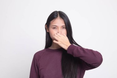 Kötü bir koku yüzünden burnunu tutan genç Asyalı kadın.